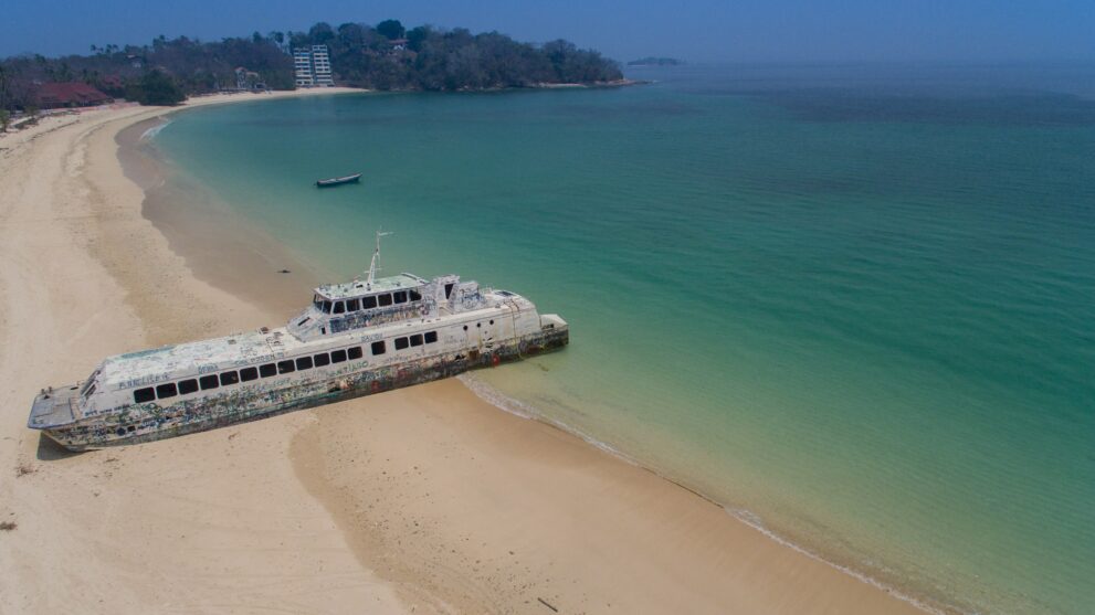 Luftbild eines gestrandeten Fährwracks am langen Sandstrand der Insel Contadora im Perlen-Archipel