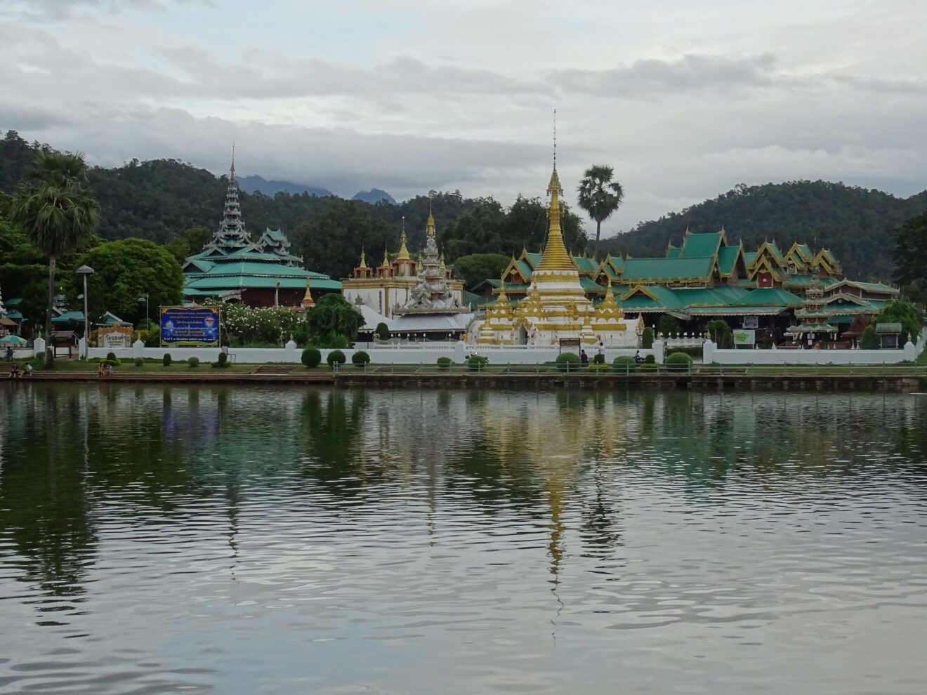 Wat Chong Klang und Wat Chong Kham spiegeln sich im See Nong Chong Kham in Mae Hong Son, dahinter bewaldete Berge