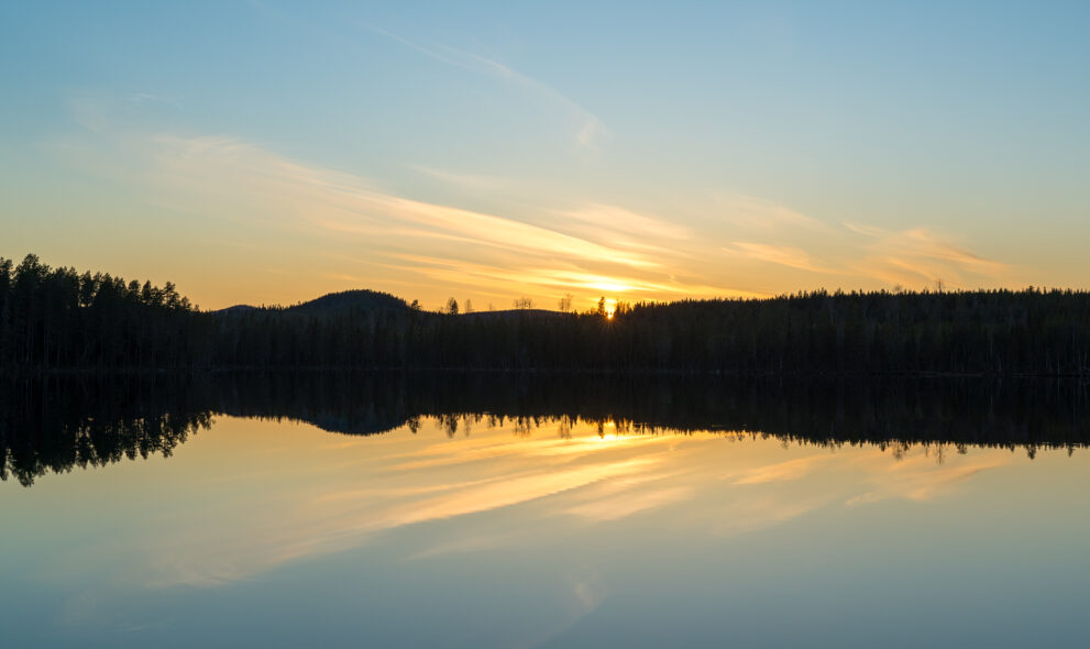 Sonnenuntergang am Sör-Holmsjön bei Örnsköldsvik, die dunkle Waldsilhouette spiegelt sich im glatten See