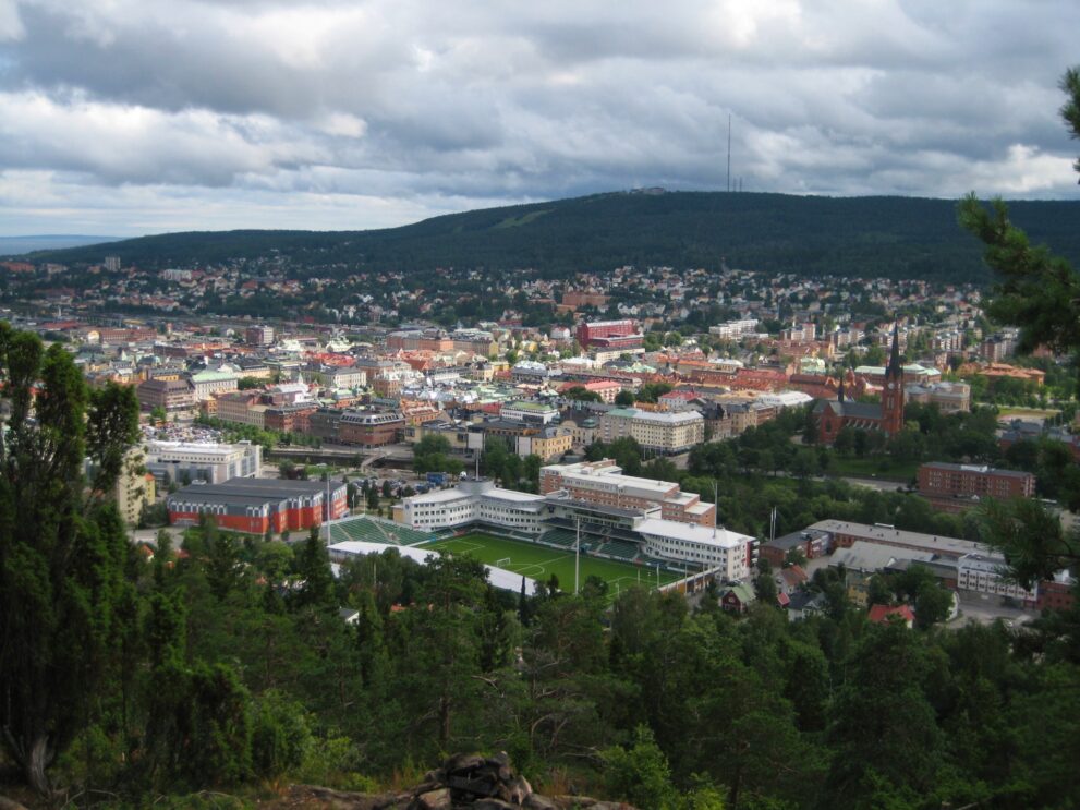 Blick vom Norra Stadsberget auf die Innenstadt von Sundsvall mit Steinhäusern und bewaldeten Hügeln dahinter