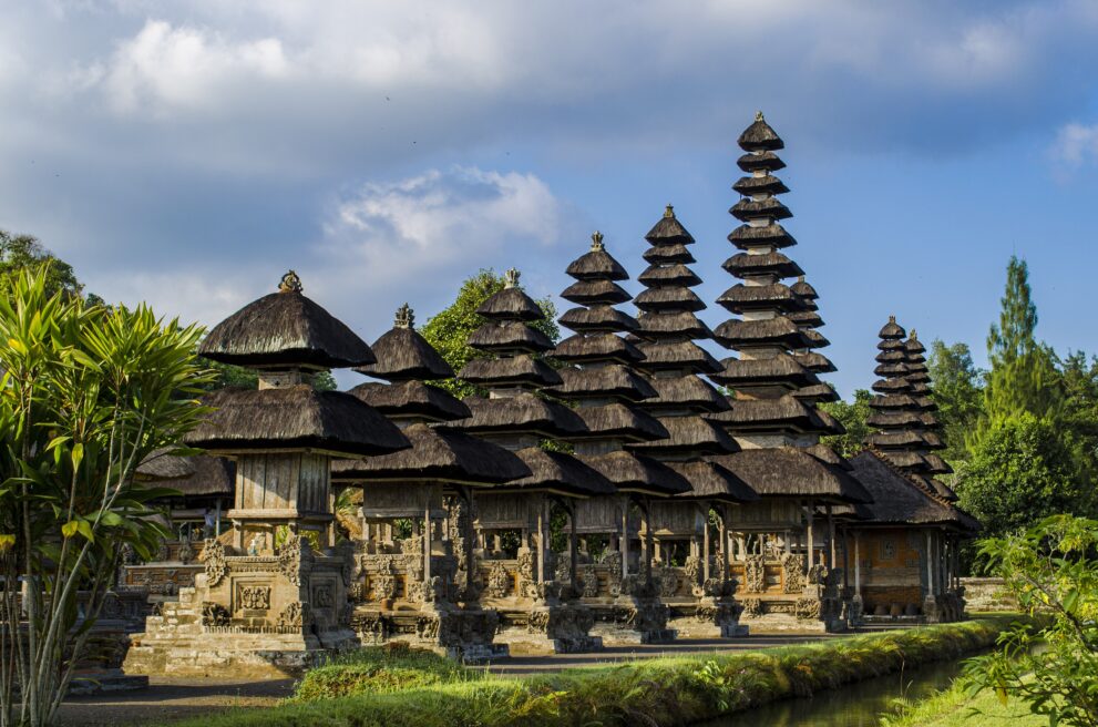 Reihe der mehrstufigen Meru-Türme im Tempel Pura Taman Ayun in Mengwi auf Bali, umgeben von Wassergraben und Garten