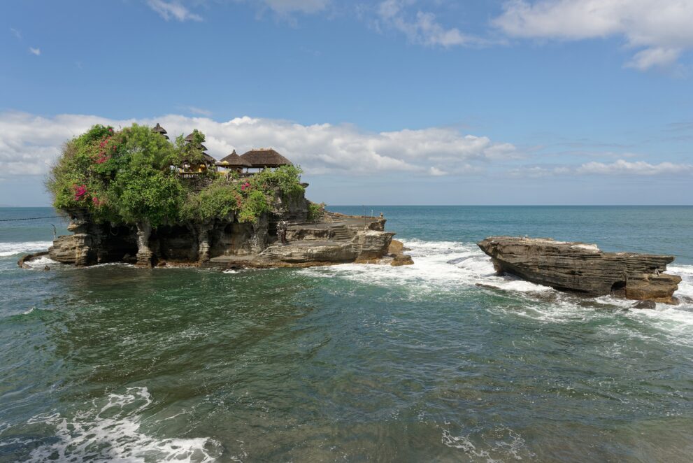 Meerestempel Pura Tanah Lot auf seinem bewachsenen Felsen bei Flut, umspült von der Brandung an der Westküste Balis