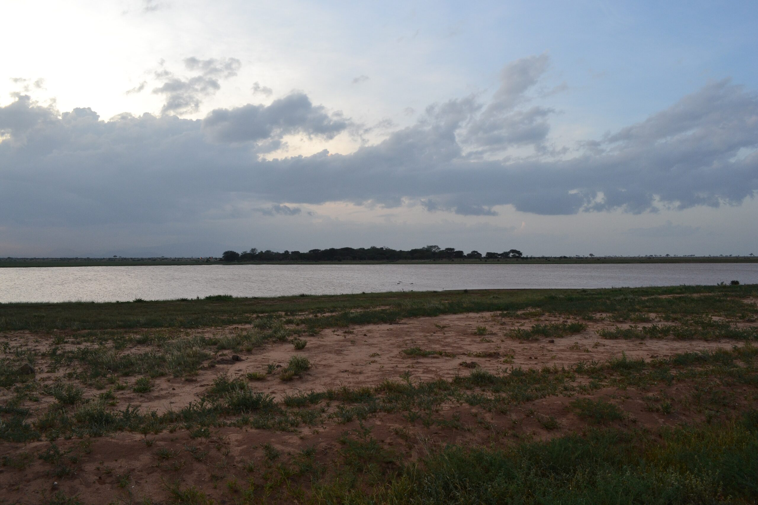 Stausee des Aruba-Damms im Tsavo-Ost-Nationalpark am Abend unter Wolkenhimmel