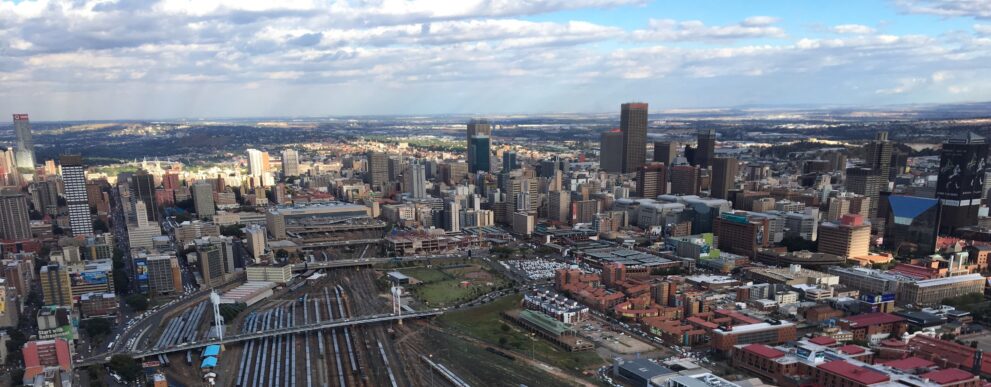 Blick über die Skyline von Johannesburg mit Hochhäusern der Innenstadt und dem Bahngelände im Vordergrund