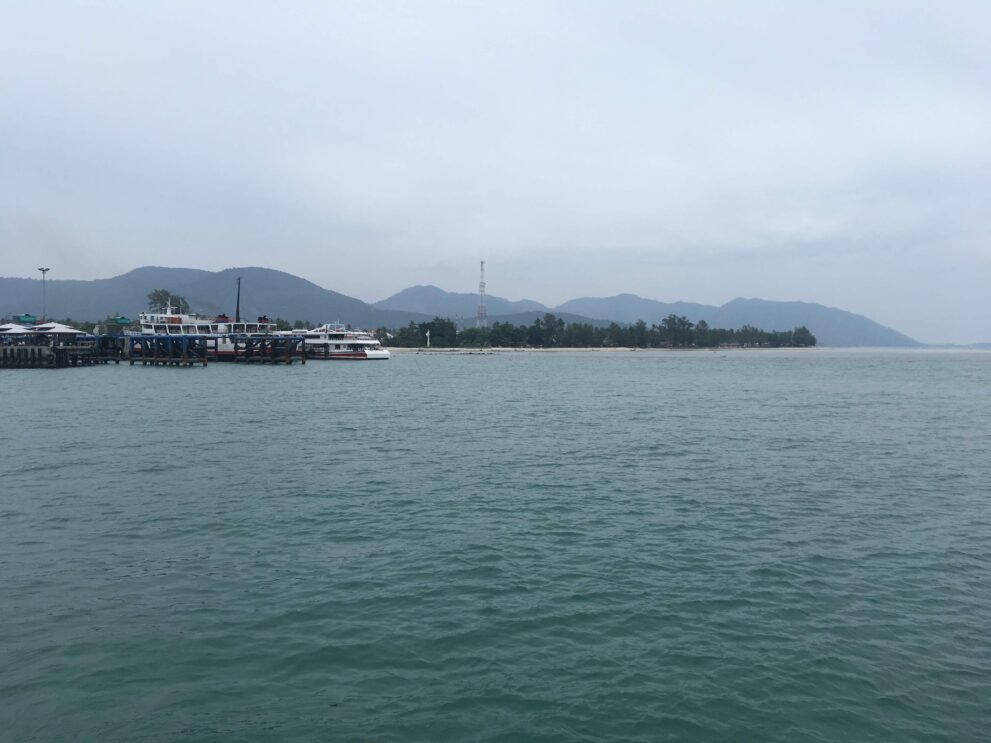 Blick von der Fähre aus Koh Samui auf die Küste von Koh Phangan mit Anlegestelle und Bergen im Hintergrund