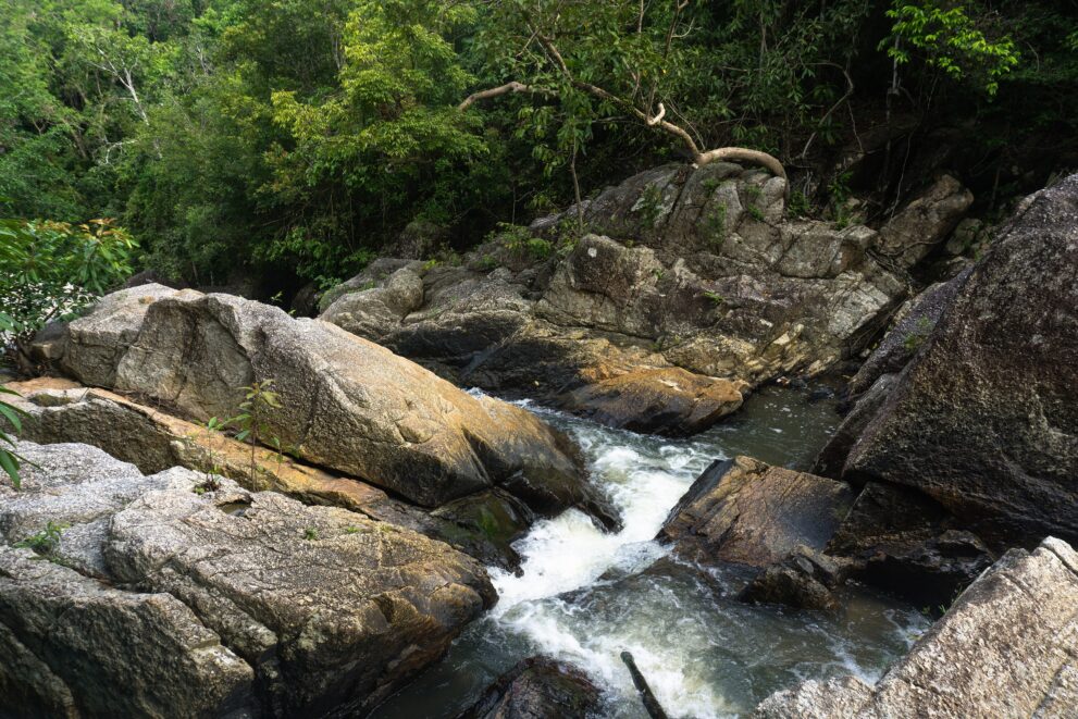 Wasser stürzt über runde Granitfelsen am Wasserfall Than Sadet im Dschungel von Koh Phangan