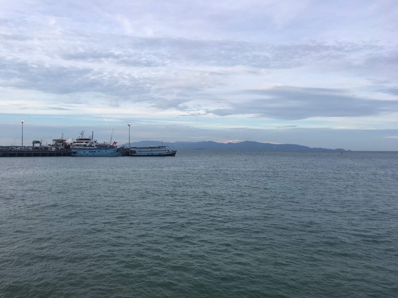 Pier von Thong Sala auf Koh Phangan mit Fähren, am Horizont die Nachbarinsel Koh Samui