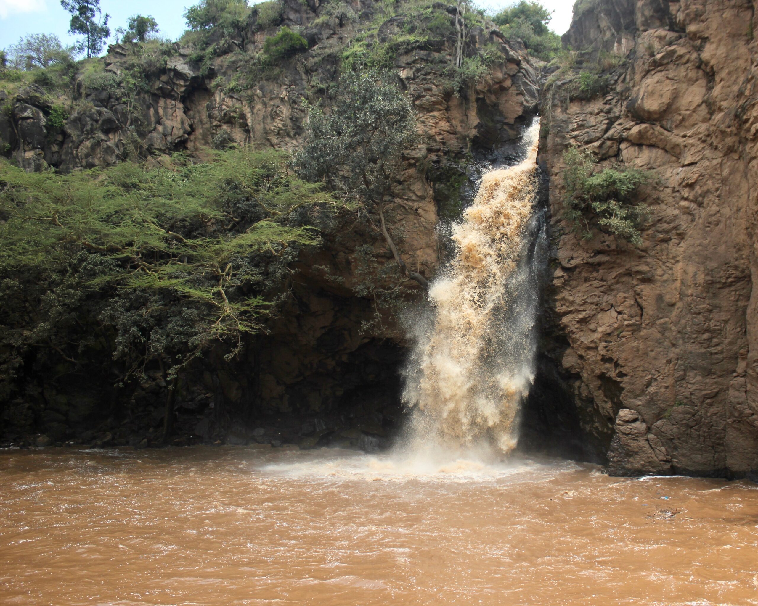 Der Makalia-Wasserfall stürzt zwischen Felswänden in ein Becken im Lake-Nakuru-Nationalpark