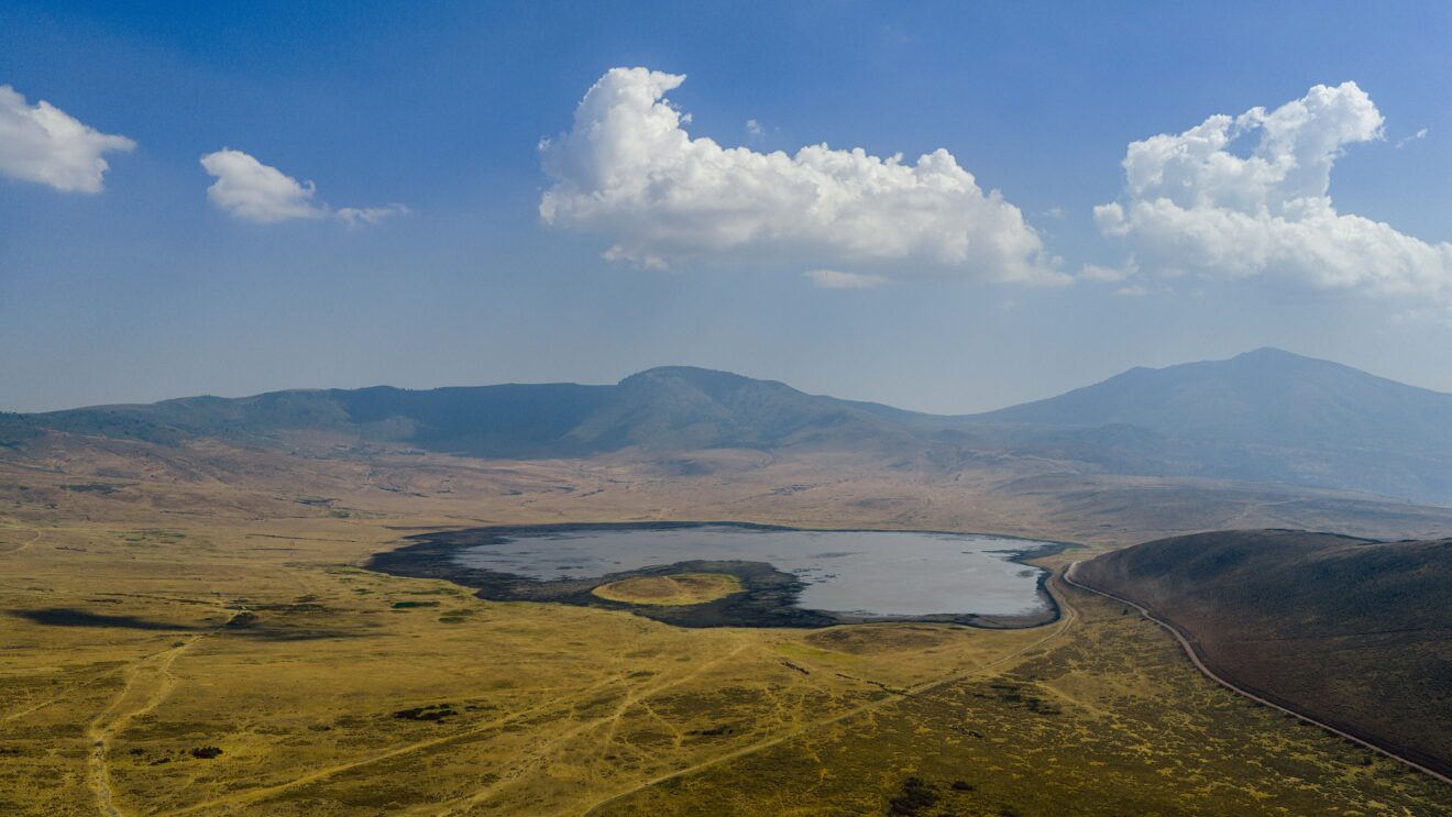 Luftbild des Ngorongoro-Kraters mit dem See auf dem Kraterboden und den Hügeln am Kraterrand in Tansania
