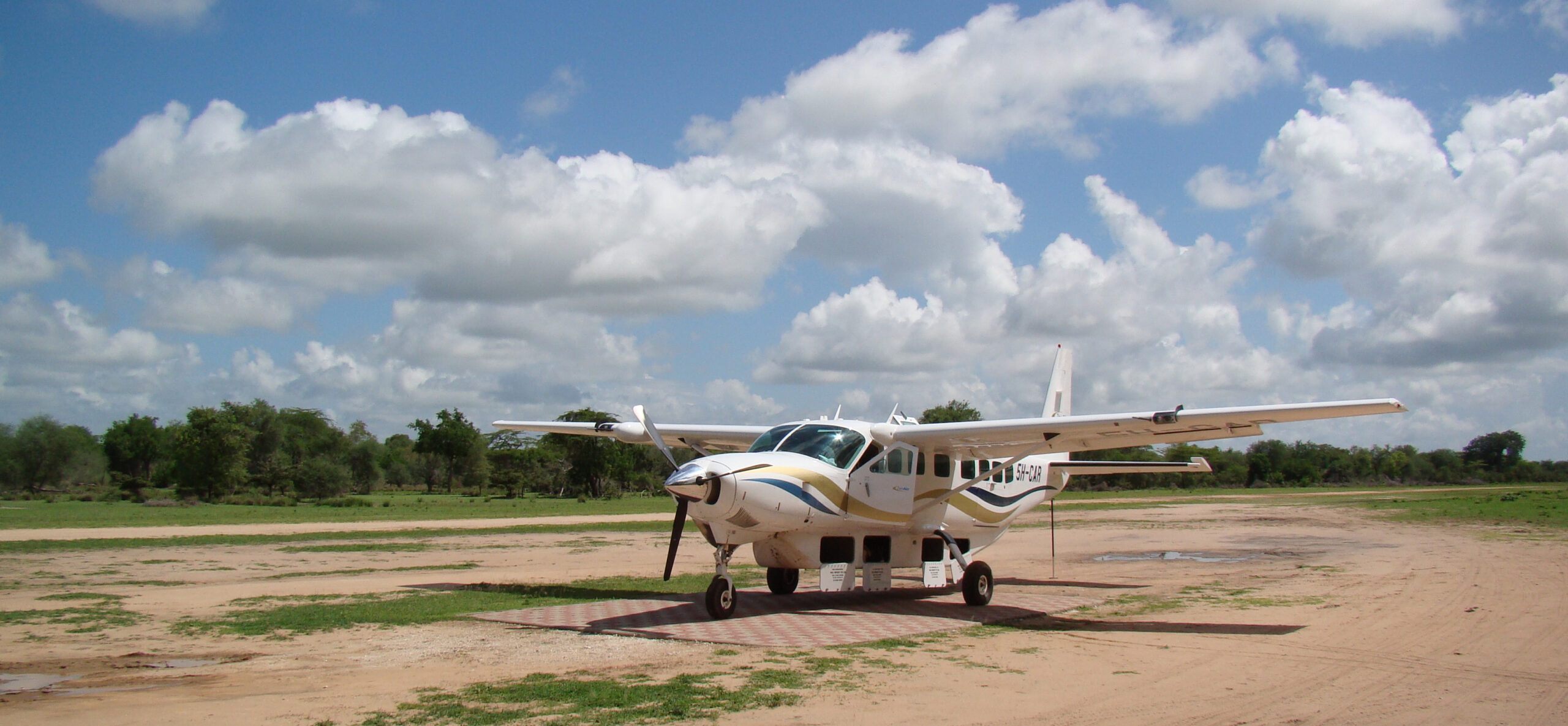 Ein weißes Kleinflugzeug von ZanAir steht auf dem Airstrip Mtemere im Nyerere-Nationalpark