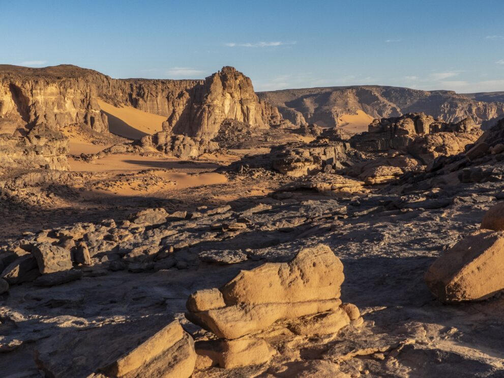 Sandsteinplatten, Felstürme und Sandflächen im Oued Intabourak im Roten Tadrart bei tiefem Licht