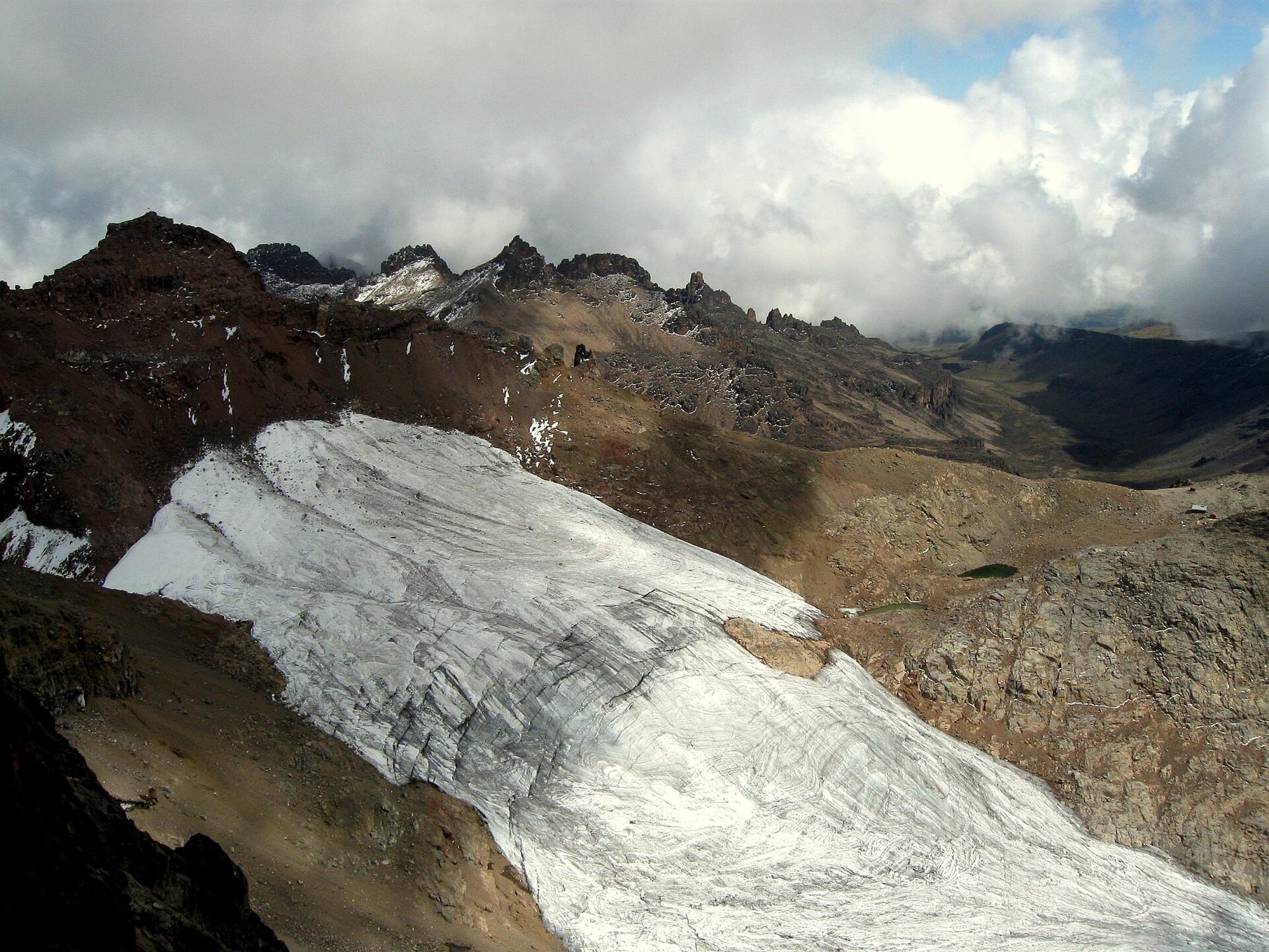 Blick von oben auf den Lewis-Gletscher als breite Eiszunge, links dahinter der Gipfel von Point Lenana, rechts klein das Austrian Hut
