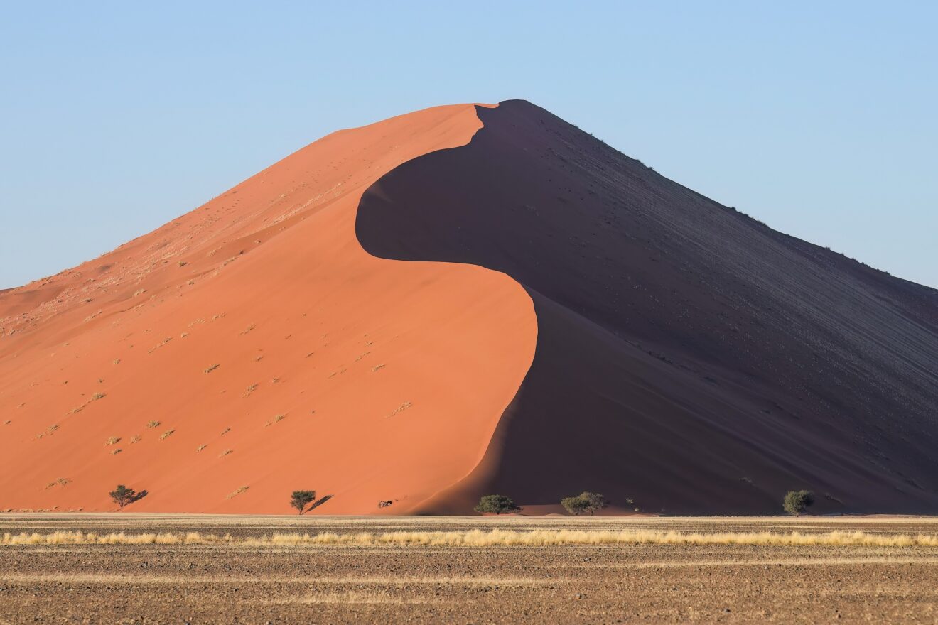 Düne 45 im Sossusvlei im Morgenlicht, rote Sandflanke mit scharfem Schattengrat im Namib-Naukluft-Park