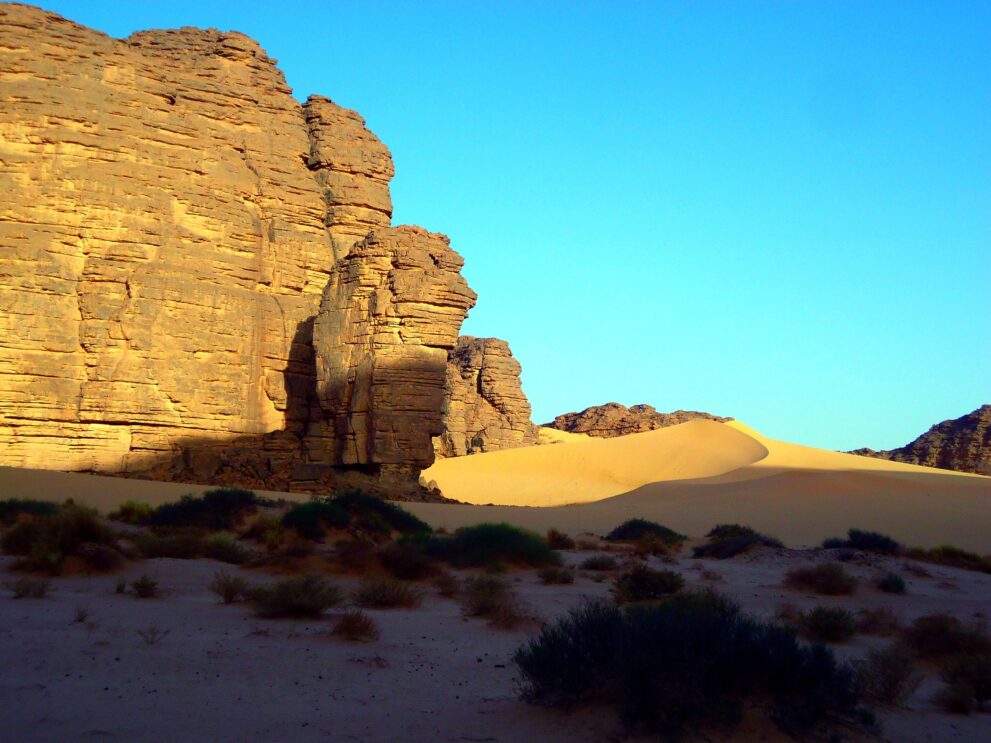Sphinxförmiger Sandsteinfelsen auf dem Weg von Tikoubaouine nach Djanet mit Düne im Hintergrund