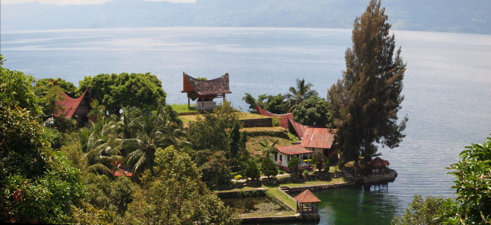 Traditionelle Batak-Häuser mit geschwungenen Dächern am Ufer des Toba-Sees bei Ambarita auf der Insel Samosir