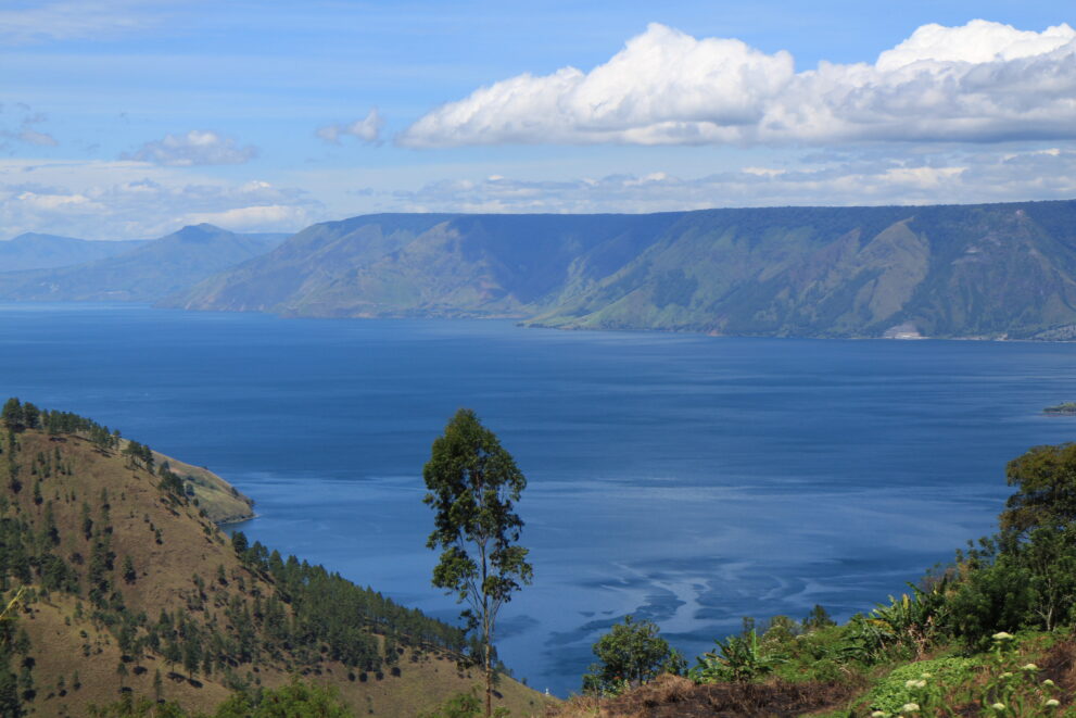 Blick von Merek über den tiefblauen Toba-See und die steilen Wände der Caldera im Hochland von Nordsumatra
