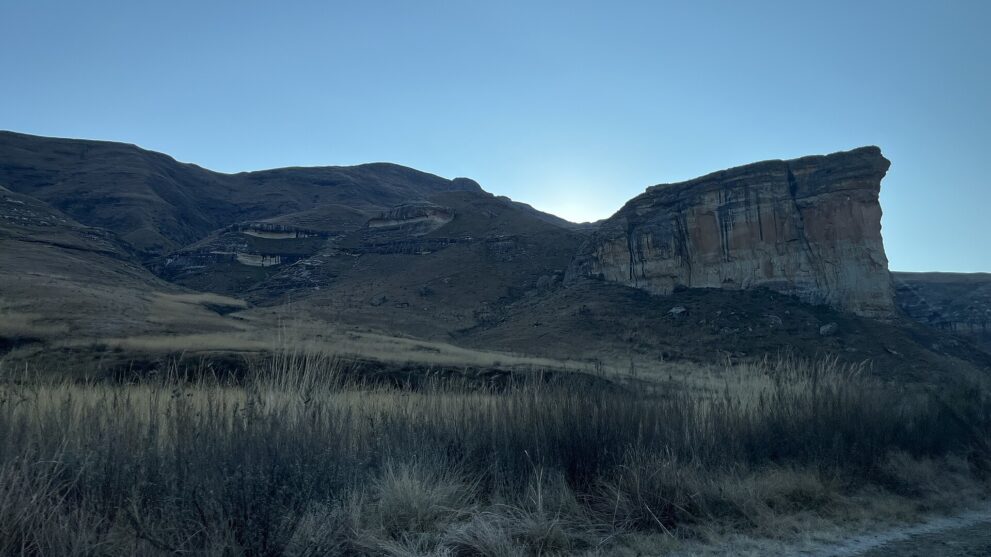 Der Brandwag-Felsen im Gegenlicht eines Wintermorgens, davor trockenes Gras