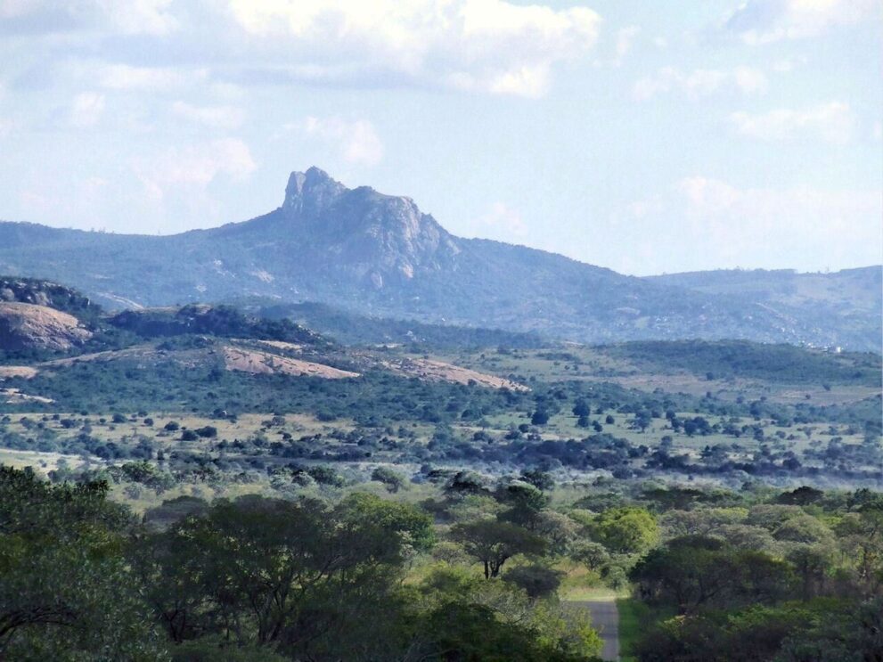 Granitkuppen und Buschland bei Berg-en-Dal, dahinter ein schroffer Felsgipfel