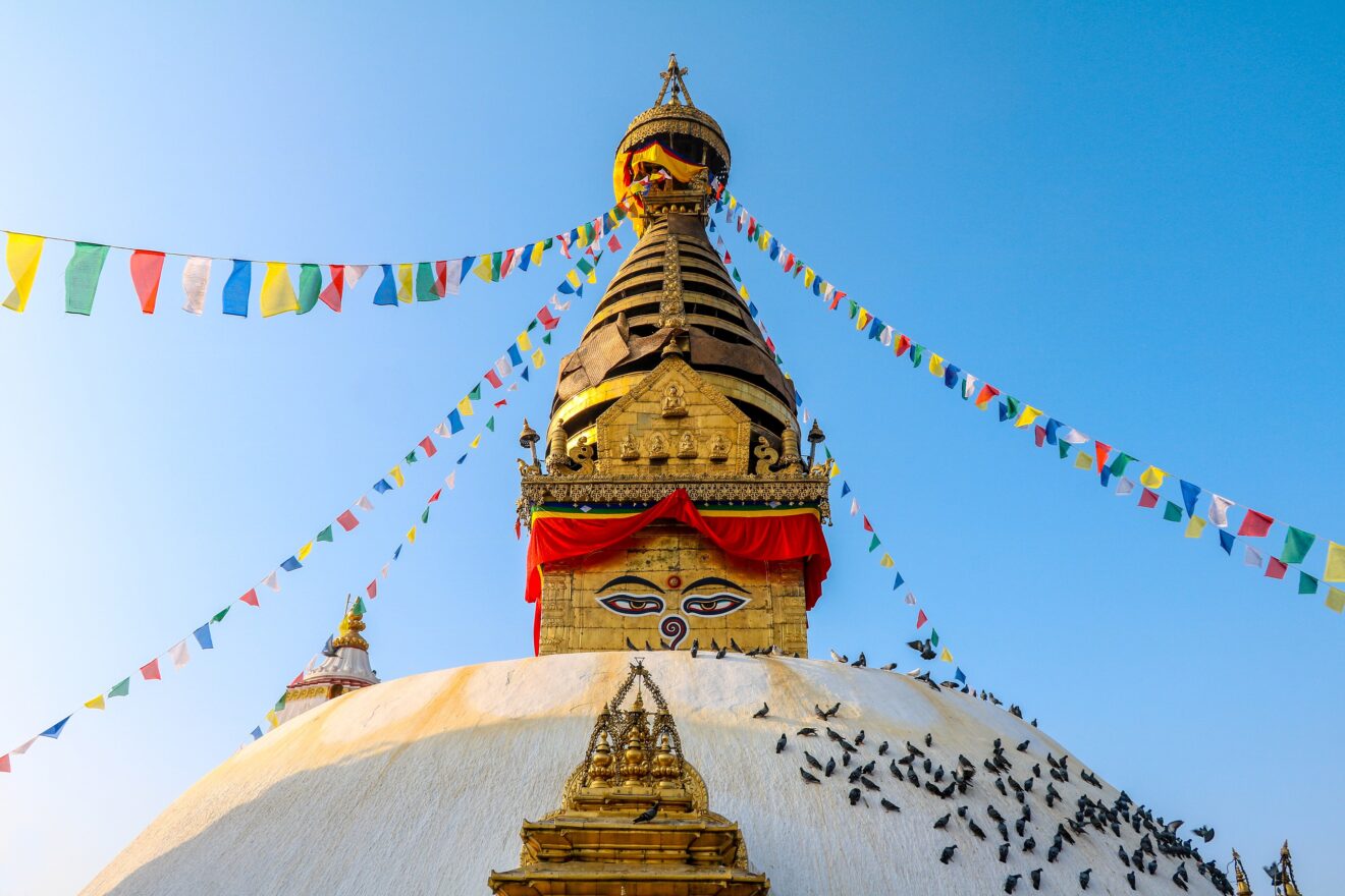 Die Stupa von Swayambhunath in Kathmandu mit Gebetsfahnen und den Augen Buddhas