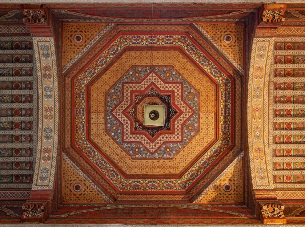 Bemalte Holzdecke mit achteckigem Sternmuster im kleinen Hof des Bahia-Palasts in Marrakesch