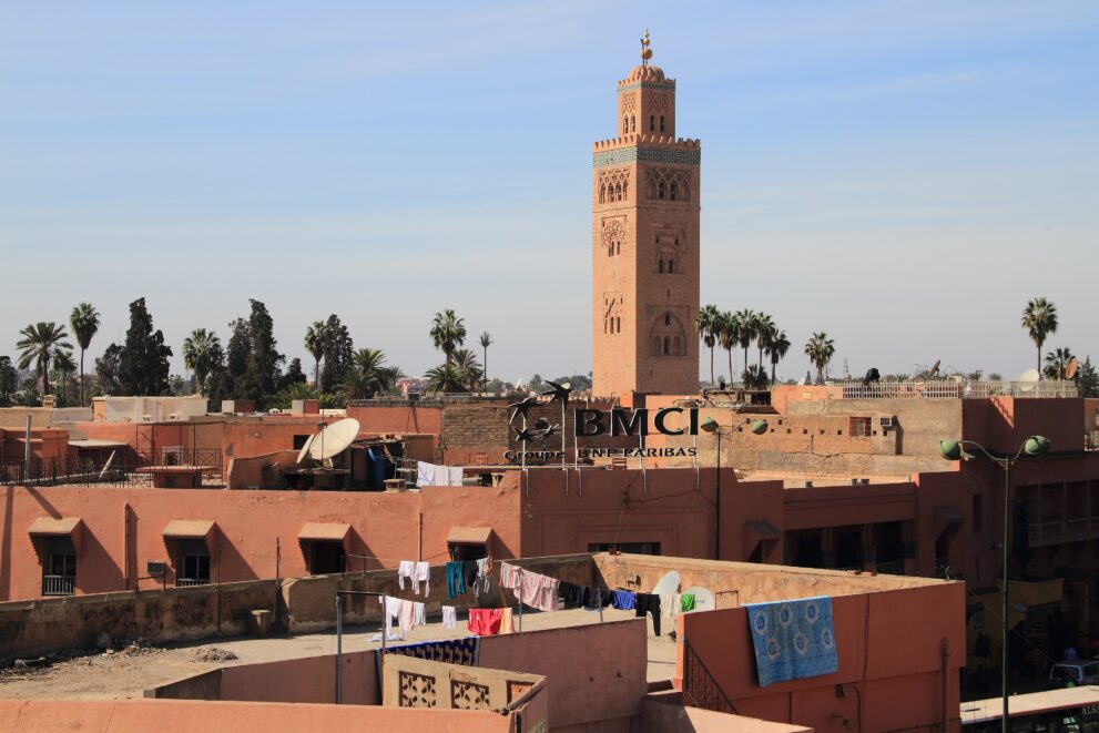 Minarett der Koutoubia-Moschee über den Flachdächern der Medina von Marrakesch unter blauem Himmel
