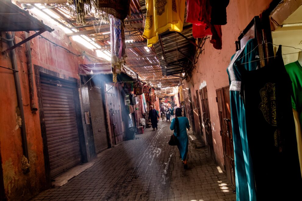 Lichtstrahlen fallen durch das Schilfdach in einen überdachten Souk der Medina von Marrakesch am Morgen