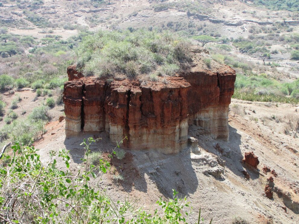 Nahaufnahme des Felsblocks in der Olduvai-Schlucht mit roten und hellen Gesteinsschichten